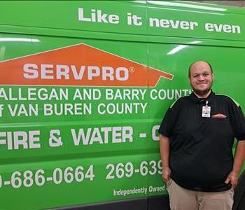 Male technician, Mike, standing in front of SERVPRO van