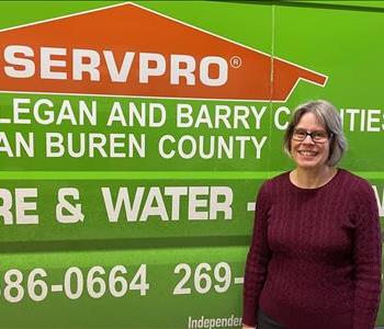 Female employee standing in front of SERVPRO van