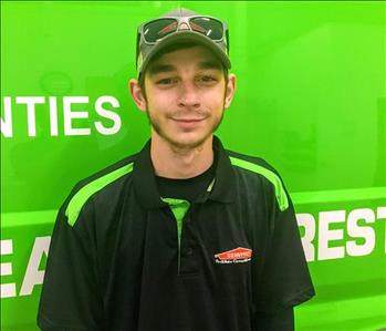 Male employee, Tyler, standing in front of SERVPRO green vehicle