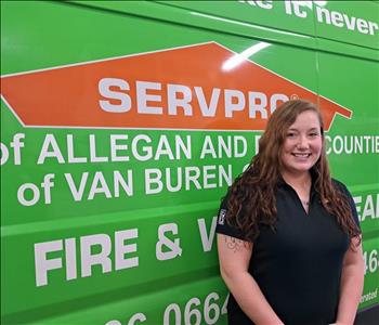 Female employee standing in front of SERVPRO van