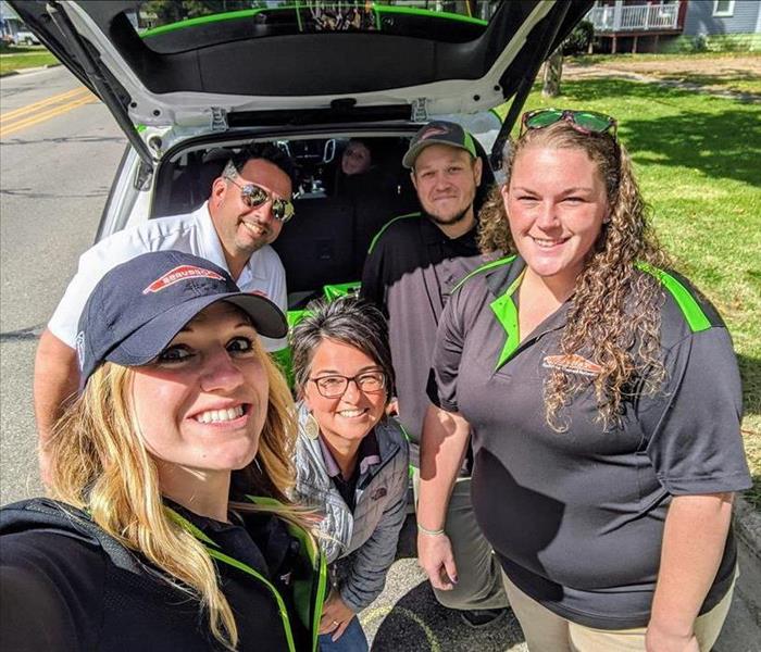 SERVPRO employees standing in front of green SERVPRO vehicle