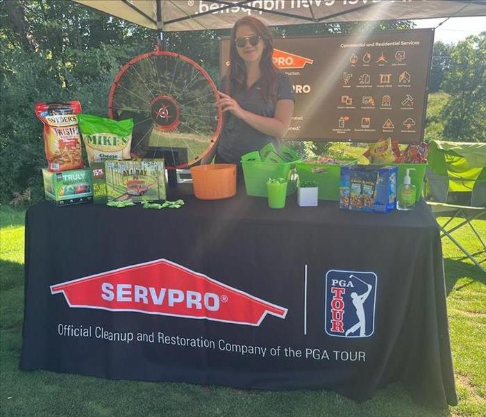 SERVPRO female rep standing behind table display under tent
