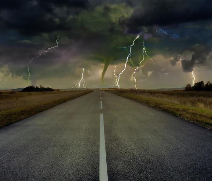 Photo of road with extreme storm happening in the background
